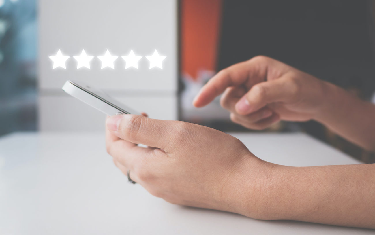 person submitting a 5 start review on their phone for a houston business