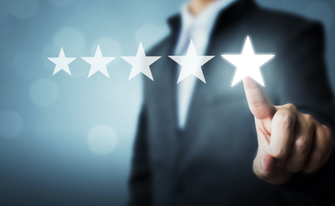 person in a suit submitting a 5 star review for a local business