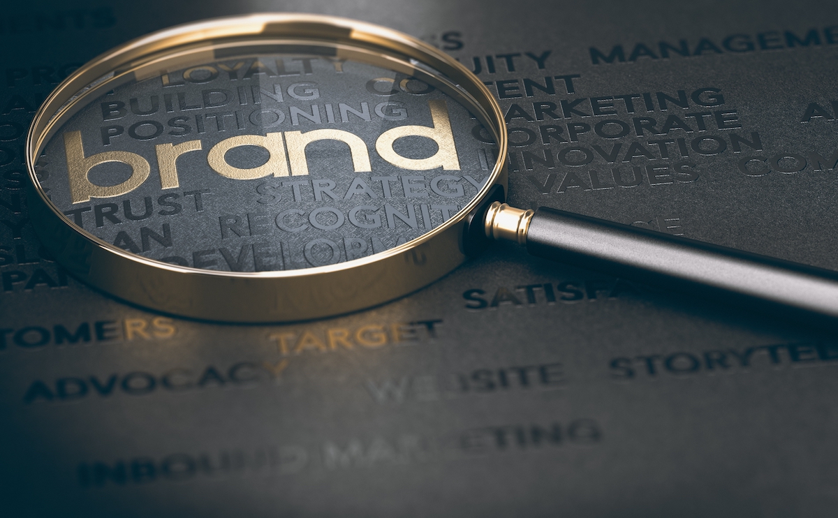 magnifying glass over the word "brand" to signify the importance of creating a brand that stands out